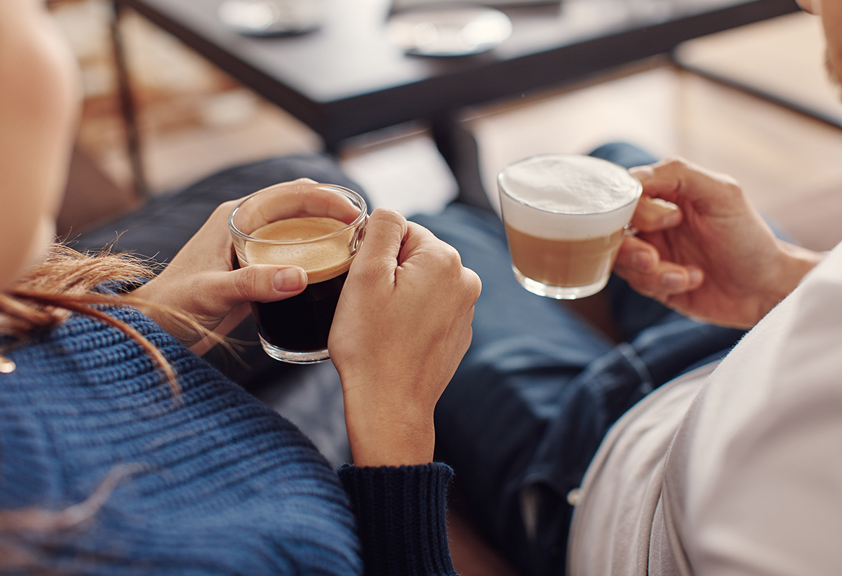 Στην φωτογραφία δείχνει ένα ζευγάρι που ο καθένας κρατάει από μία κούπα καφέ